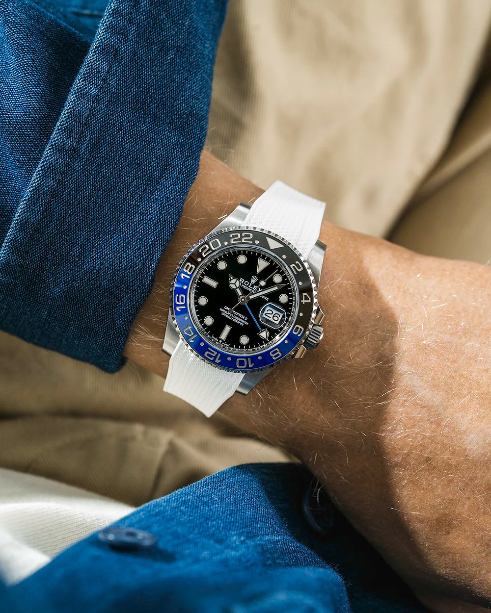 White vertech rubber strap on Rolex 126710 batman wrist shot with blue shirt