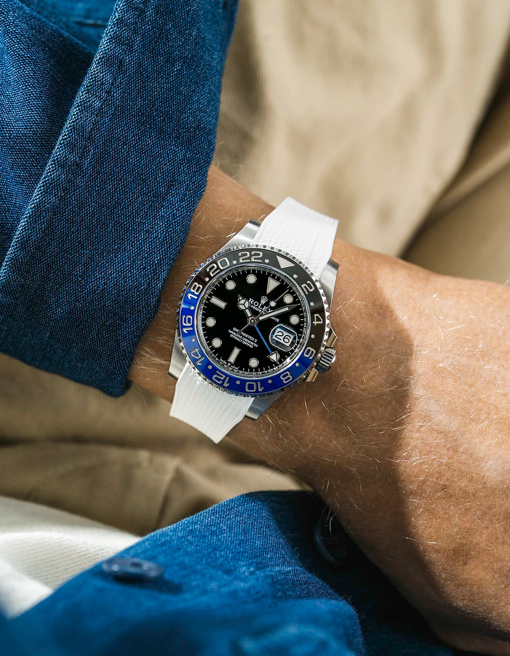 White vertech rubber strap on Rolex 126710 batman wrist shot with blue shirt