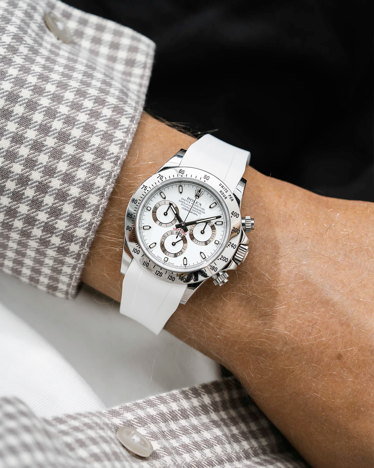 Close-up of a person wearing a white Rolex Daytona watch with a white jacket sleeve and a FKM rubber watch strap from Wristbuddys