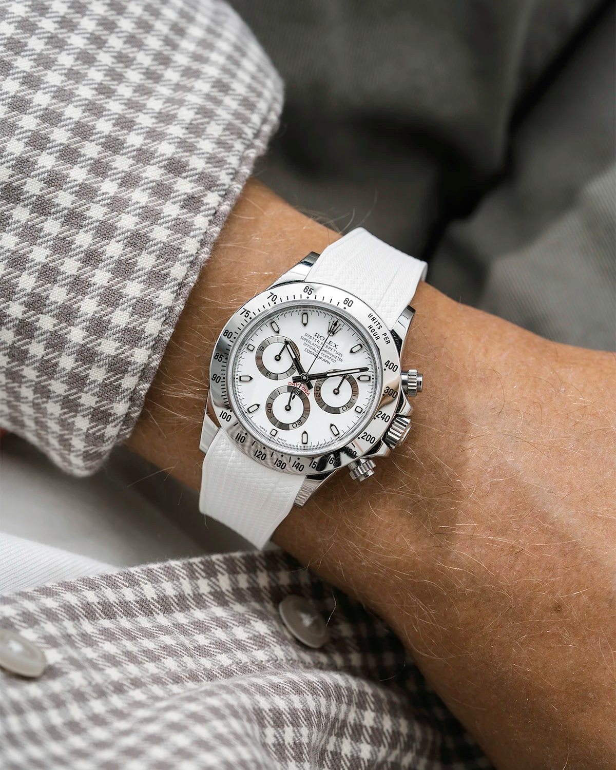 Close-up of a person wearing a white Rolex Daytona watch with a beige white stiped shirt sleeve and a white vertech FKM rubber watch strap from Wristbuddys