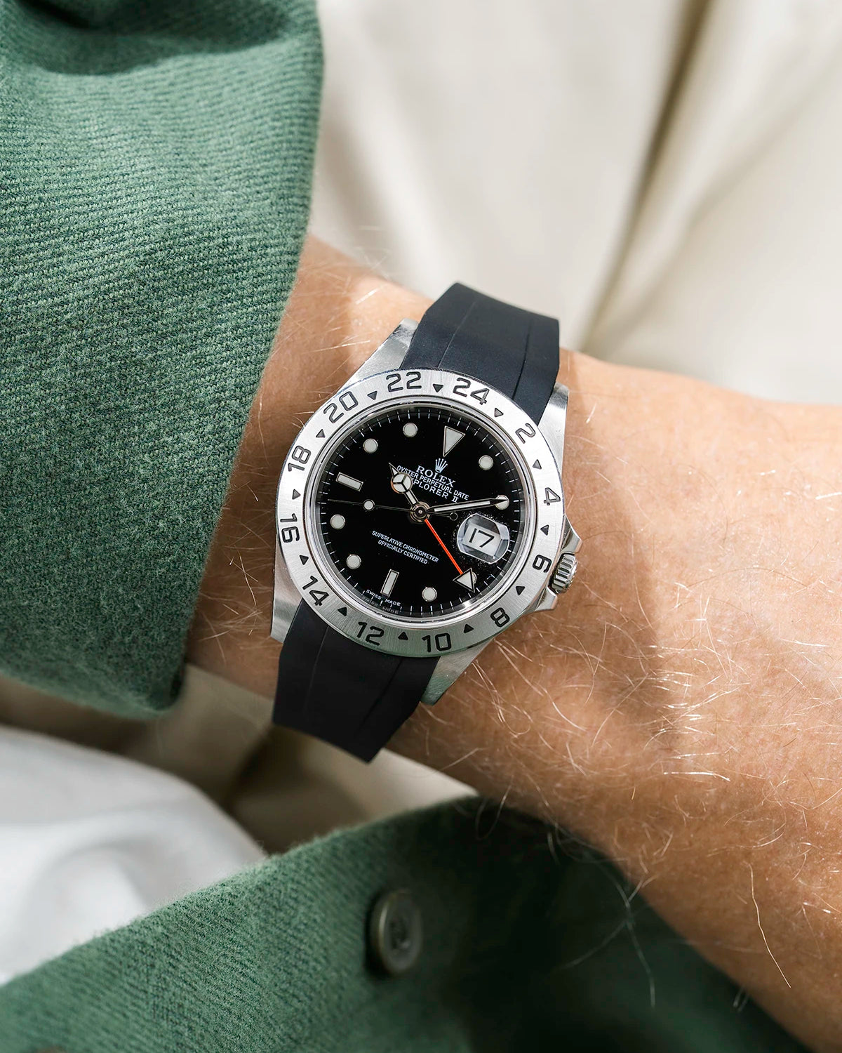 Close-up of a person wearing a Rolex Explorer 2 16570 model watch with a green jacket sleeve and a black FKM rubber watch strap from Wristbuddys