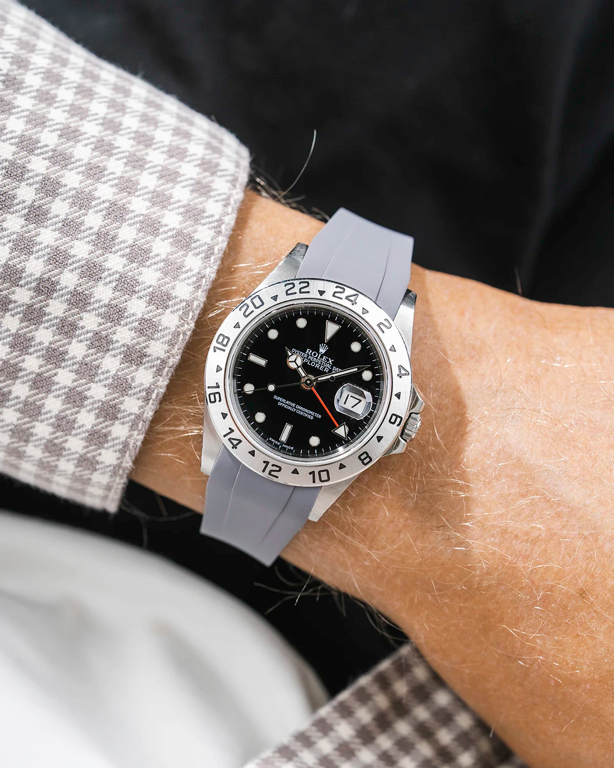 Close-up of a person wearing a Rolex Explorer 2 16570 model watch with a white beige jacket sleeve and a grey FKM rubber watch strap from Wristbuddys