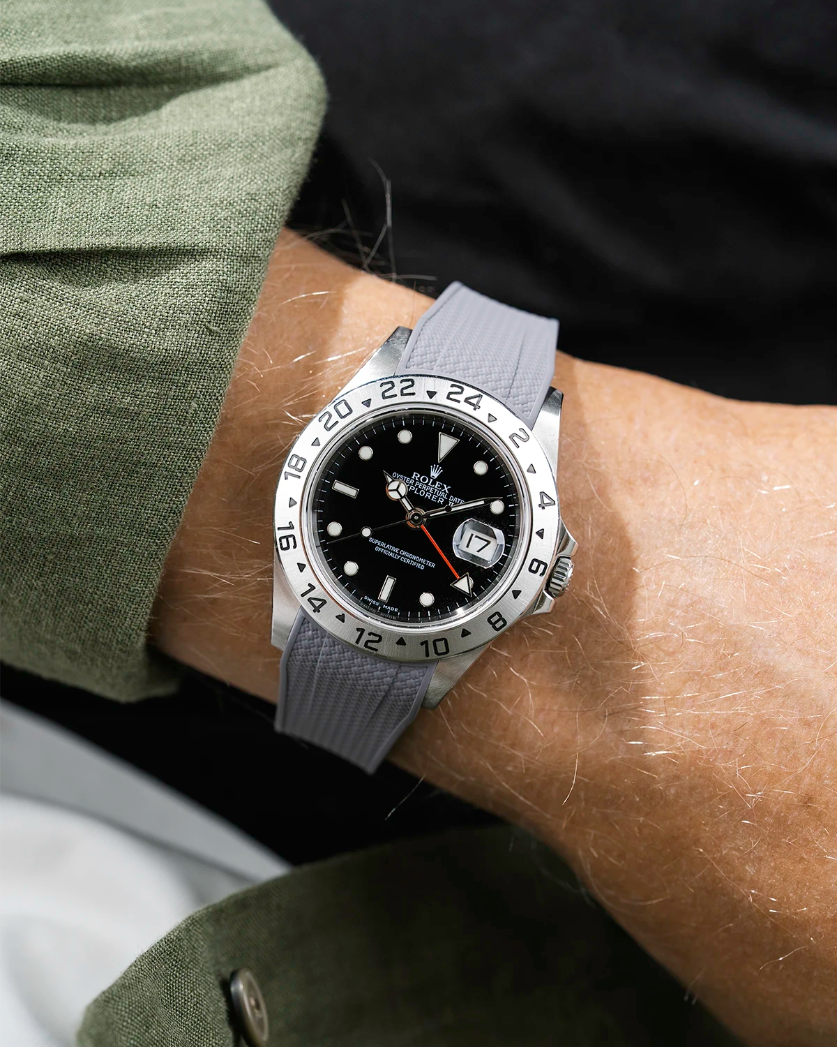 Close-up of a person wearing a Rolex Explorer 2 16570 model watch with a green jacket sleeve and a grey Vertech FKM rubber watch strap from Wristbuddys