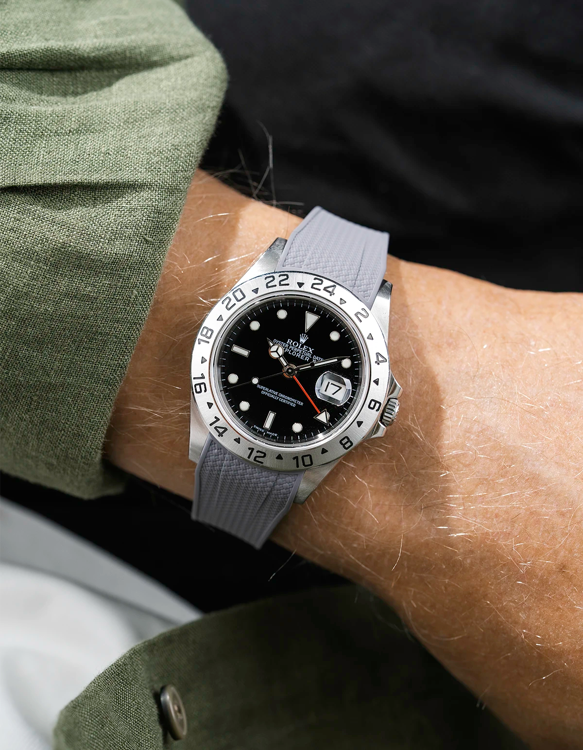 Close-up of a person wearing a Rolex Explorer 2 16570 model watch with a green jacket sleeve and a grey Vertech FKM rubber watch strap from Wristbuddys