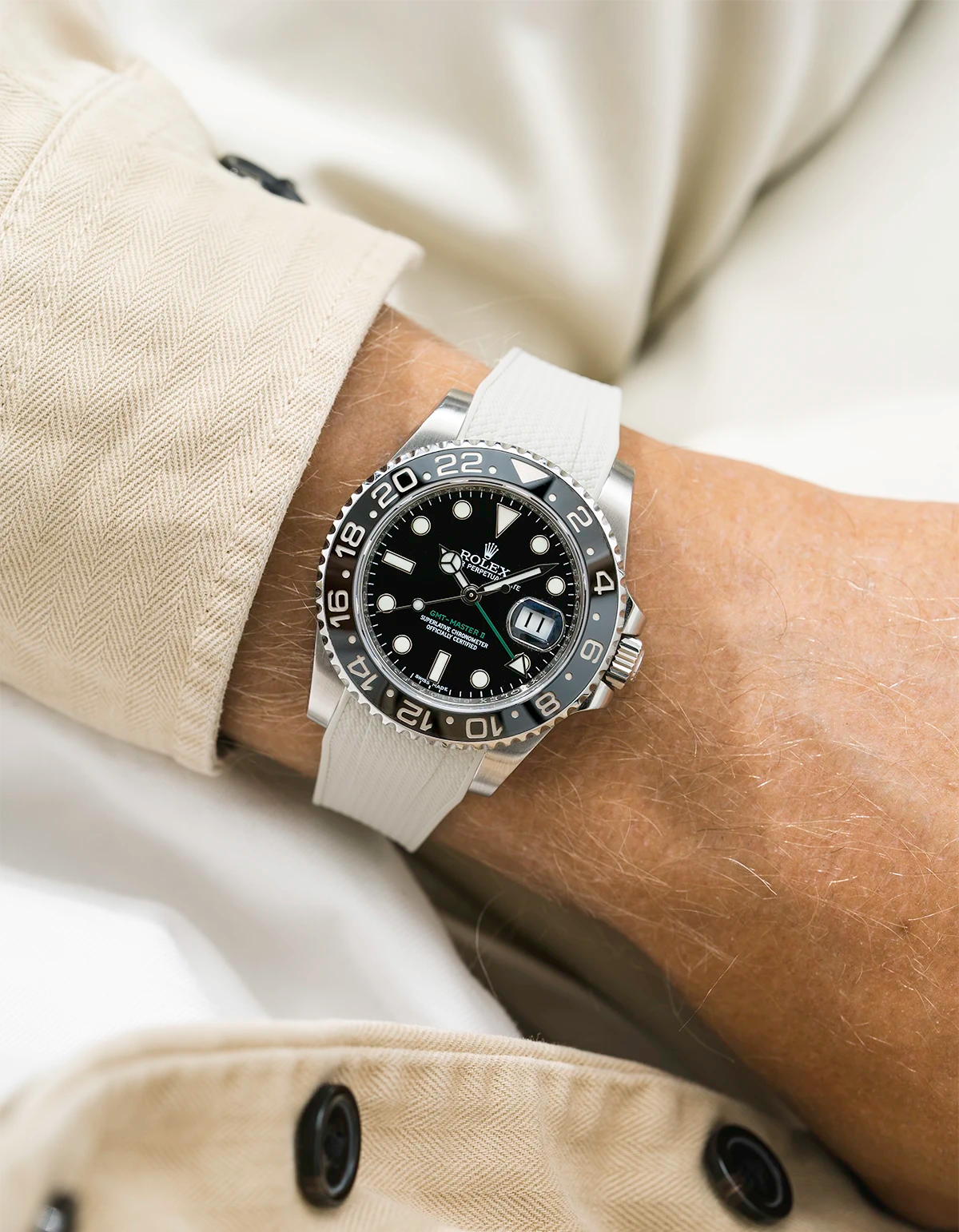 Close-up of a person wearing a Rolex GMT Master Green hand 116710 model watch with beige jacket sleeve and a beige vertech FKM rubber watch strap from Wristbuddys