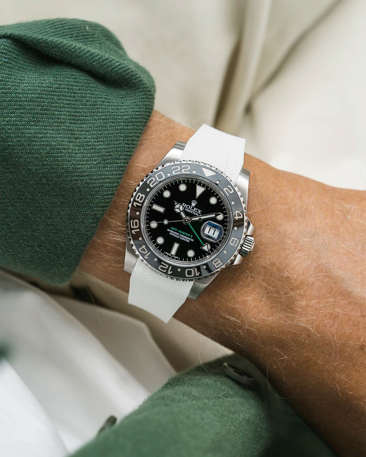 Close-up of a person wearing a Rolex GMT Master Green hand 116710 model watch with green jacket sleeve and a white vertech FKM rubber watch strap from Wristbuddys