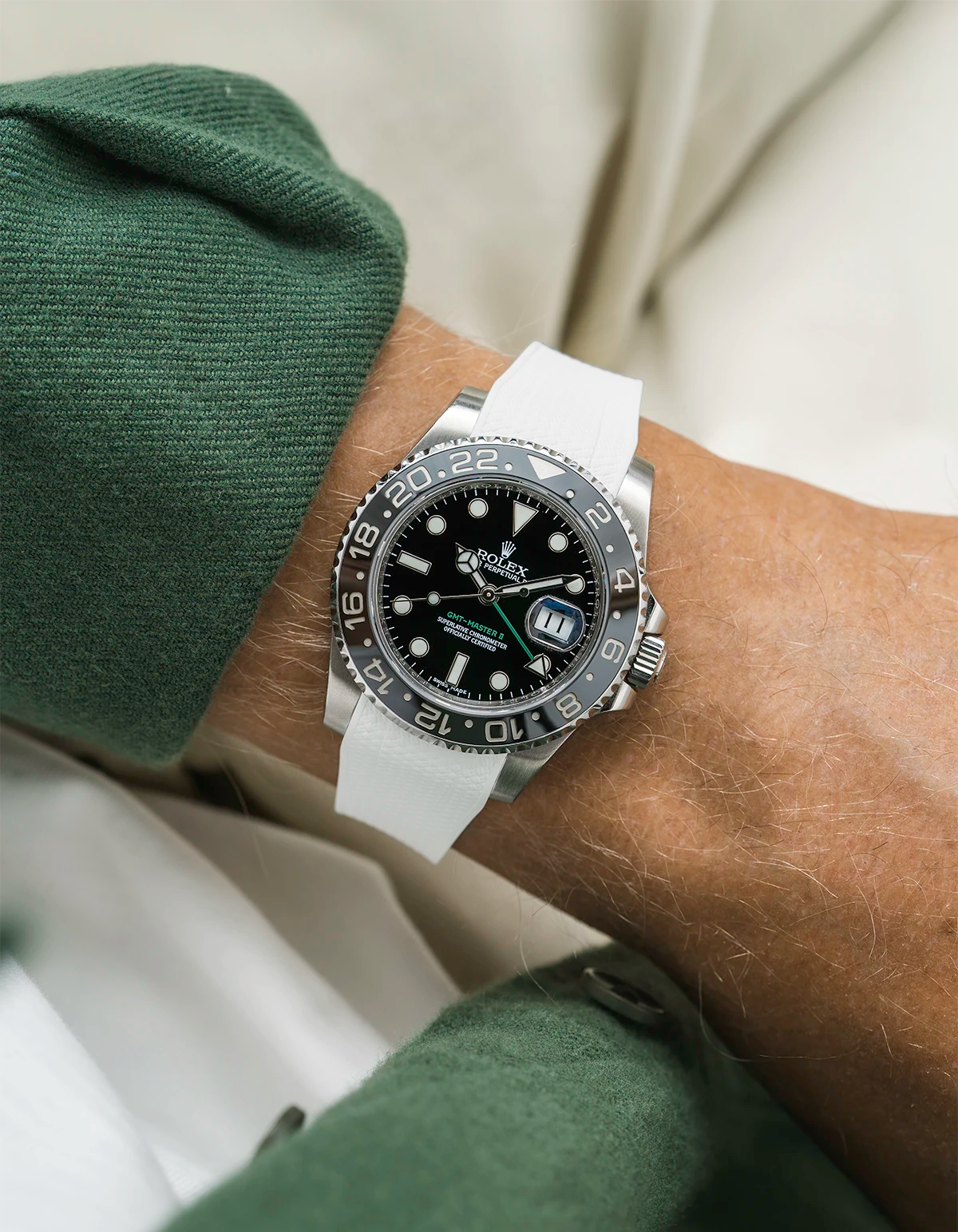 Close-up of a person wearing a Rolex GMT Master Green hand 116710 model watch with green jacket sleeve and a white vertech FKM rubber watch strap from Wristbuddys
