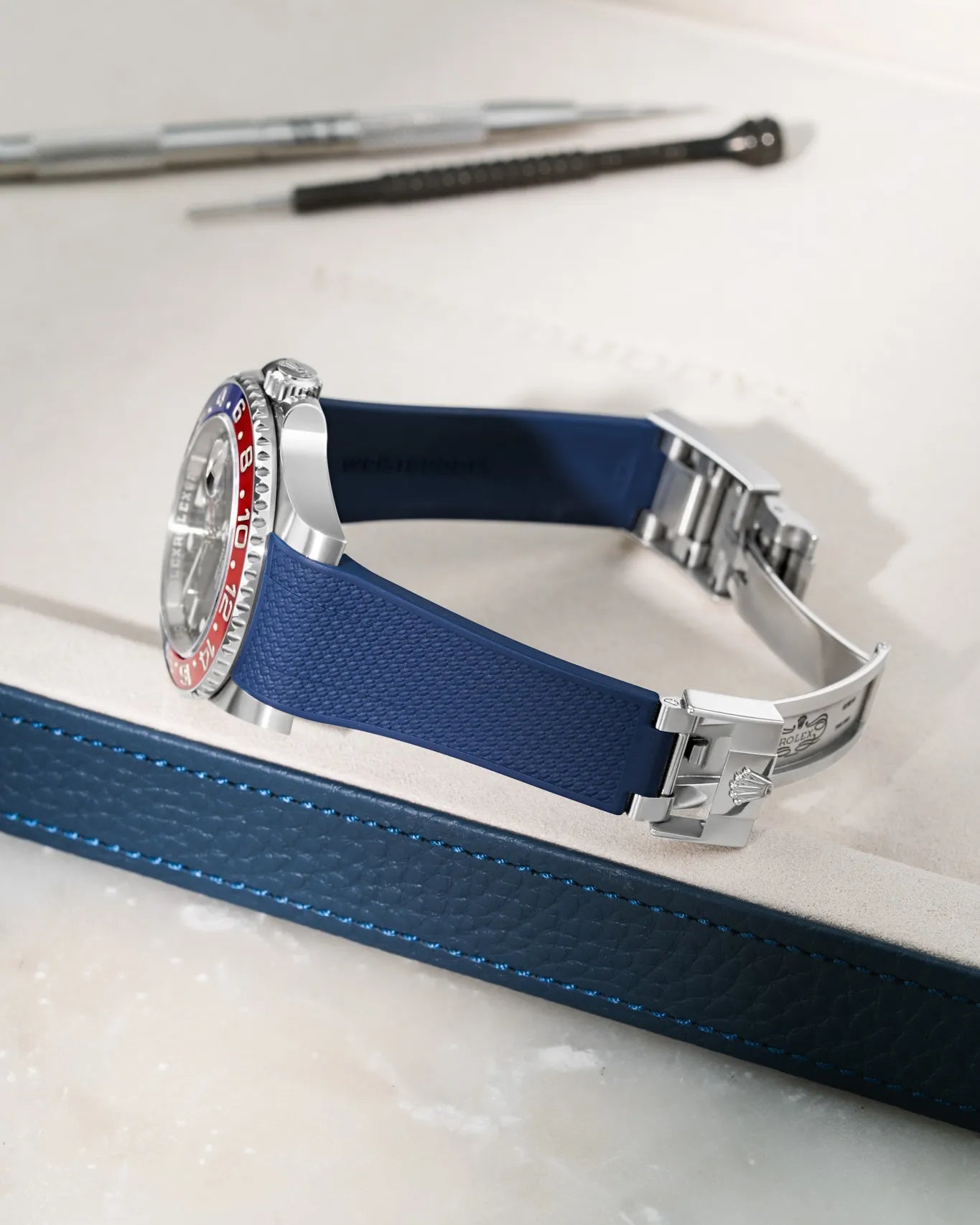 Navy Blue textured FKM rubber watch band for Rolex GMT Master II 126710/116710 Pepsi, seamless case integration, mounted with original clasp on a leather tray.