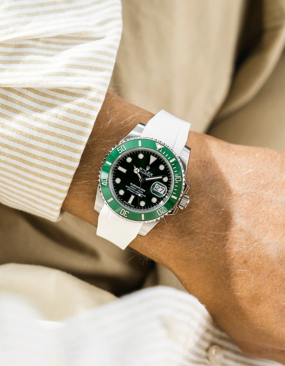 Close-up of a wrist wearing a Rolex Submariner on a Wristbuddys FKM Rubber watch strap and white strap with a blurred background
