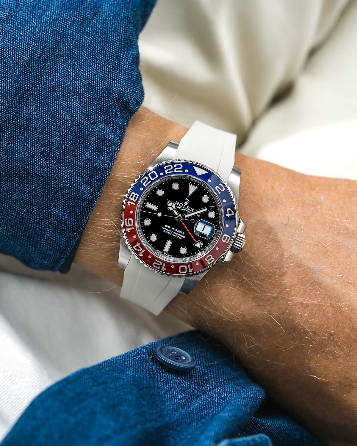 Close-up of a person wearing a Rolex GMT Master 2 Pepsi model watch with a blue jacket sleeve and a beige FKM rubber watch strap from Wristbuddys
