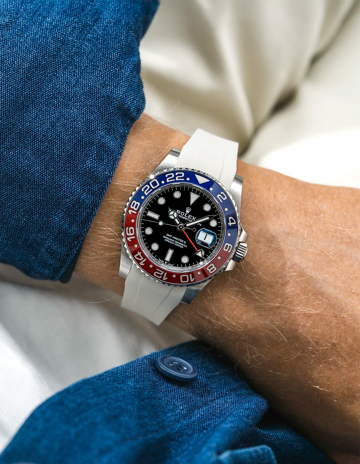 Close-up of a person wearing a Rolex GMT Master 2 Pepsi model watch with a blue jacket sleeve and a beige FKM rubber watch strap from Wristbuddys