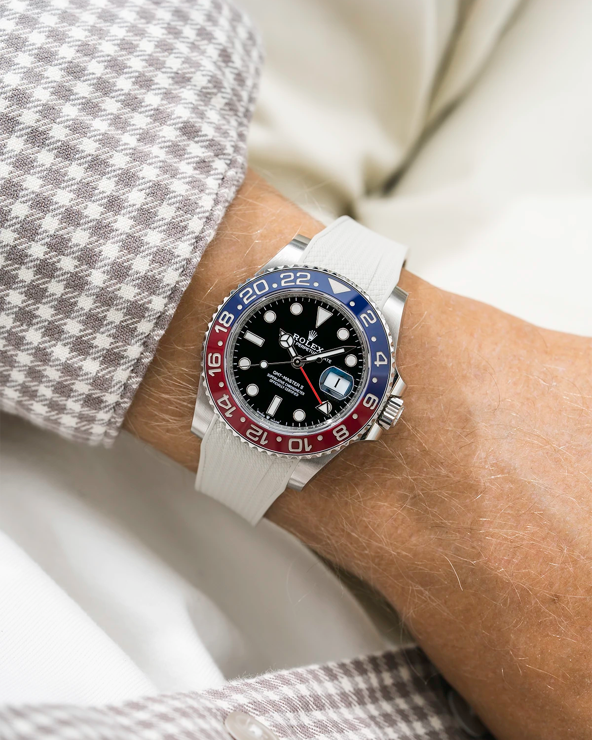 Close-up of a person wearing a Rolex GMT Master 2 Pepsi model watch with beige white jacket sleeve and a beige vertech FKM rubber watch strap from Wristbuddys