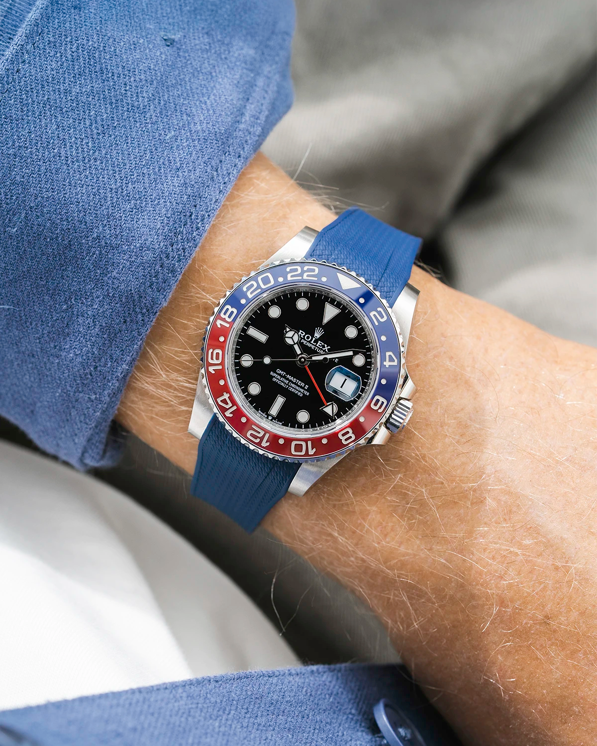 Close-up of a person wearing a Rolex GMT Master 2 Pepsi model watch with blue jacket sleeve and a navy blue vertech FKM rubber watch strap from Wristbuddys