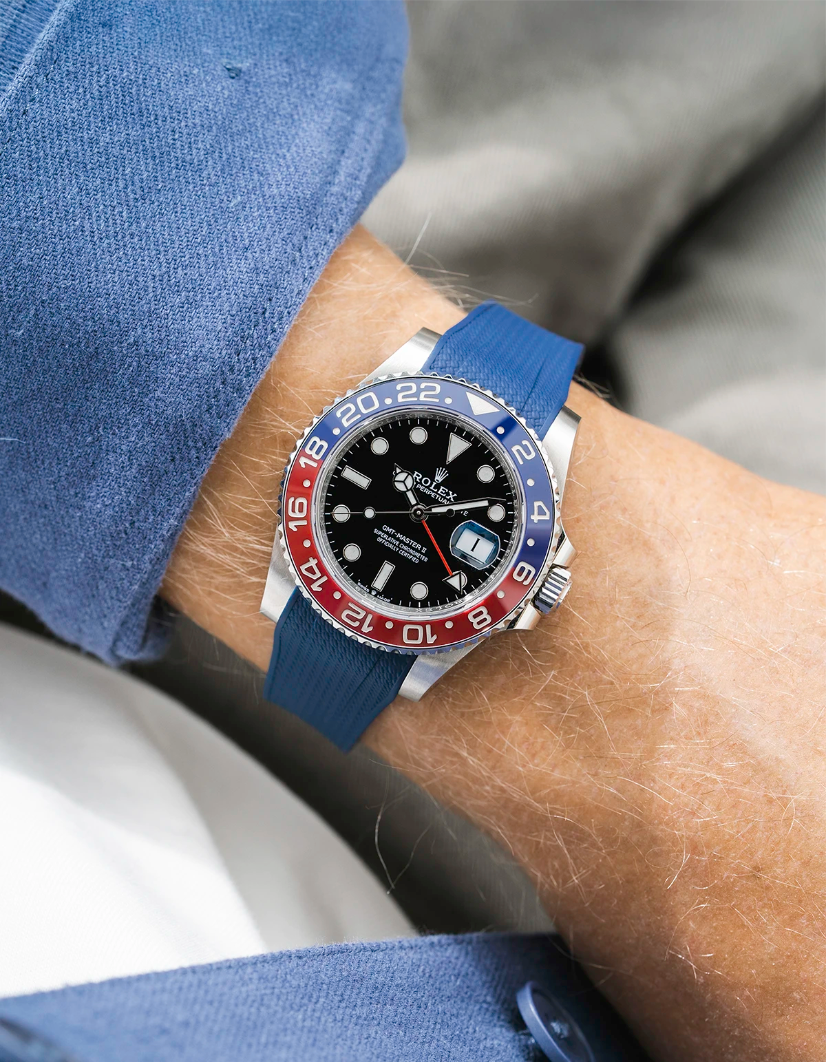 Close-up of a person wearing a Rolex GMT Master 2 Pepsi model watch with blue jacket sleeve and a navy blue vertech FKM rubber watch strap from Wristbuddys