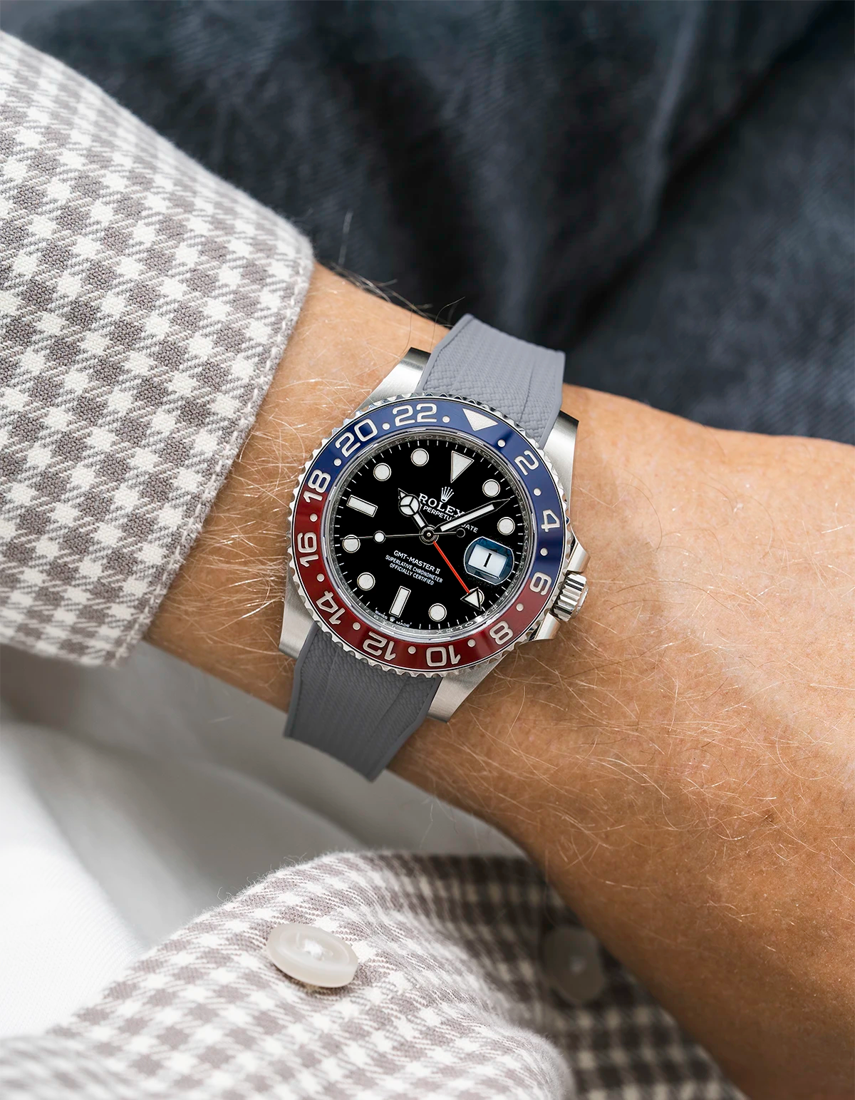 Close-up of a person wearing a Rolex GMT Master 2 Pepsi model watch with beige white jacket sleeve and a grey vertech FKM rubber watch strap from Wristbuddys