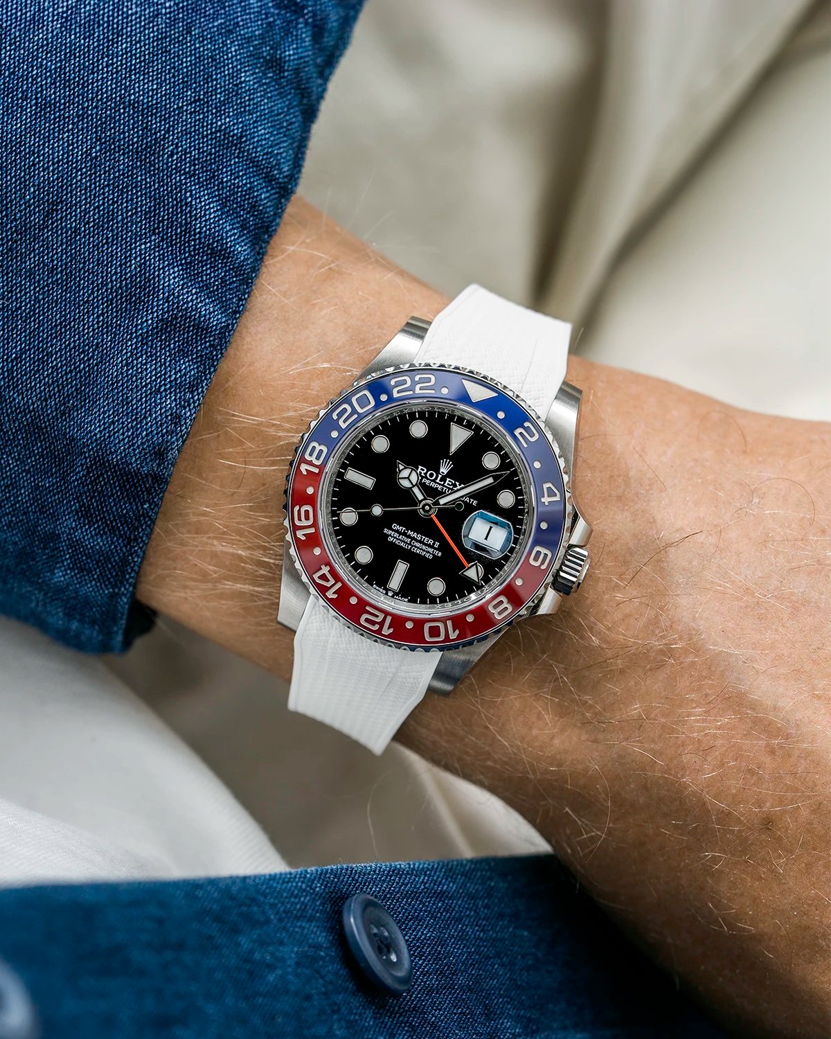 Close-up of a person wearing a Rolex GMT Master 2 Pepsi model watch with blue jacket sleeve and a white vertech FKM rubber watch strap from Wristbuddys