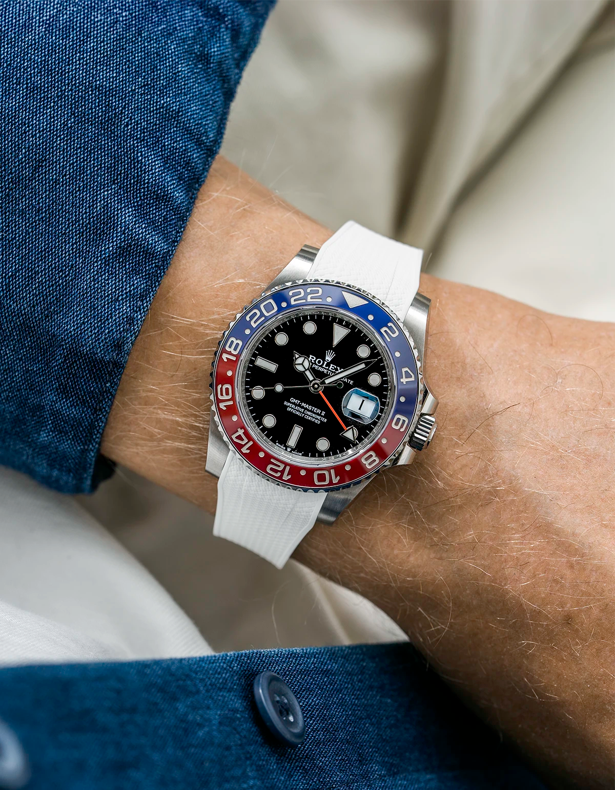 Close-up of a person wearing a Rolex GMT Master 2 Pepsi model watch with blue jacket sleeve and a white vertech FKM rubber watch strap from Wristbuddys