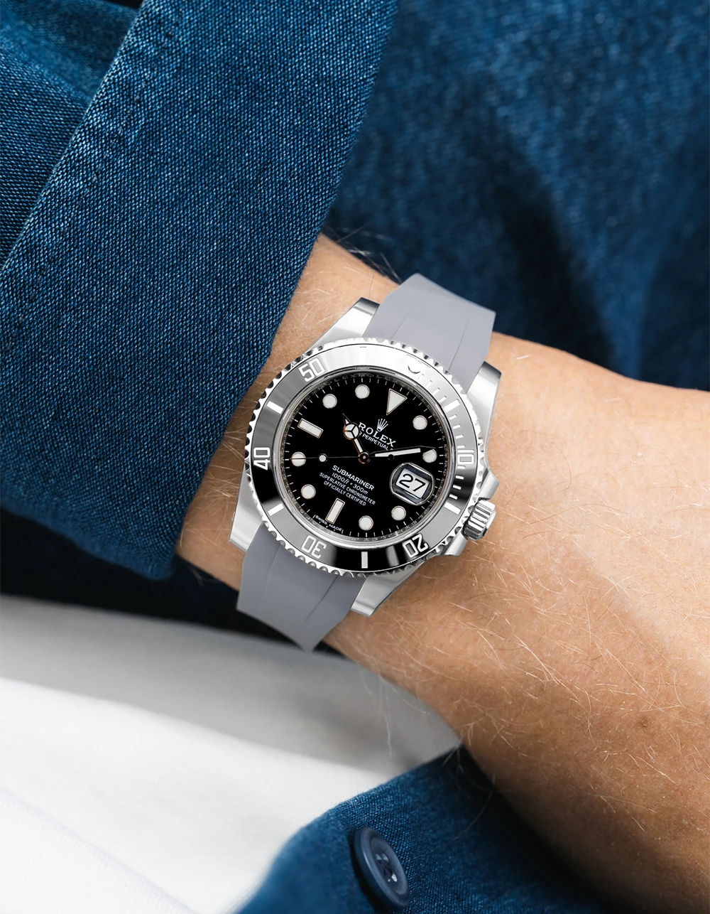 Rolex Submariner on a grey Wristbuddys FKM Rubber watch strap on a person's wrist with a blue shirt