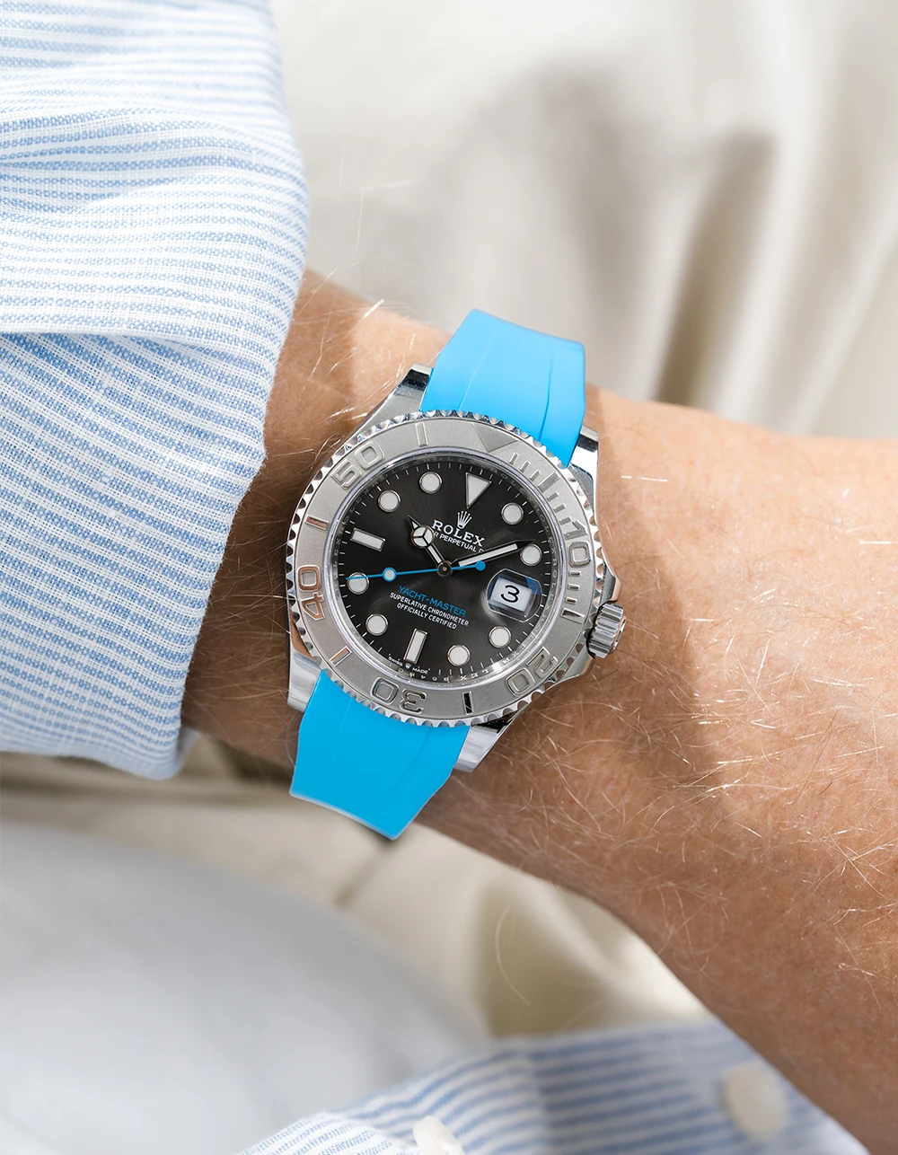 Close-up of a person wearing a Rolex YachtMaster 2 126622 / 116622 model watch with a light blue shirt sleeve and a capri FKM rubber watch strap from Wristbuddys