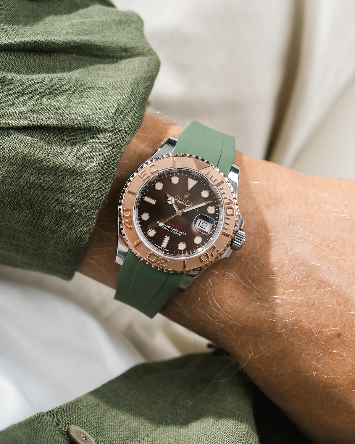 Close-up of a person wearing a Rolex YachtMaster 2 126622 / 116622 model watch with a green shirt sleeve and a green FKM rubber watch strap from Wristbuddys