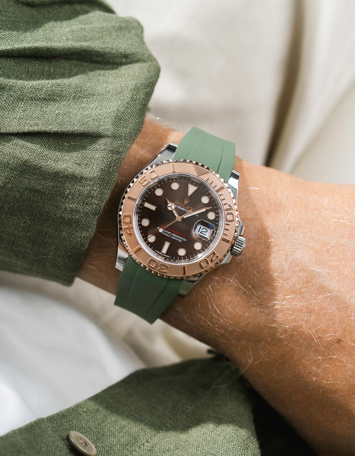 Close-up of a person wearing a Rolex YachtMaster 2 126622 / 116622 model watch with a green shirt sleeve and a green FKM rubber watch strap from Wristbuddys