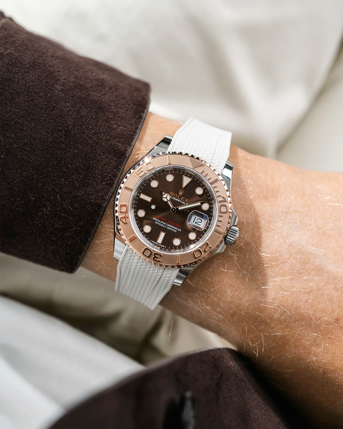 Close-up of a person wearing a Rolex YachtMaster 2 126622 / 116622 model watch with a brown shirt sleeve and a Capri beige Vertech FKM rubber watch strap from Wristbuddys