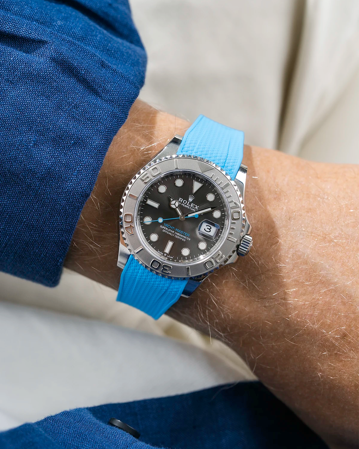 Close-up of a person wearing a Rolex YachtMaster 2 126622 / 116622 model watch with a blue shirt sleeve and a Capri Blue Vertech FKM rubber watch strap from Wristbuddys