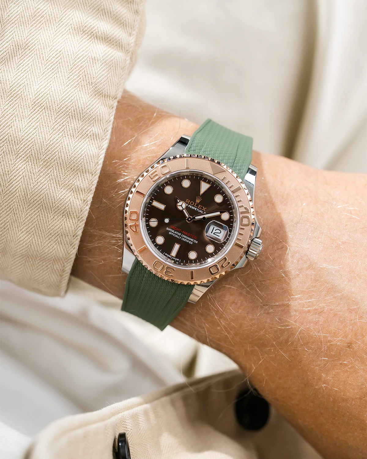 Close-up of a person wearing a Rolex YachtMaster 2 126622 / 116622 model watch with a beige shirt sleeve and a Capri green Vertech FKM rubber watch strap from Wristbuddys