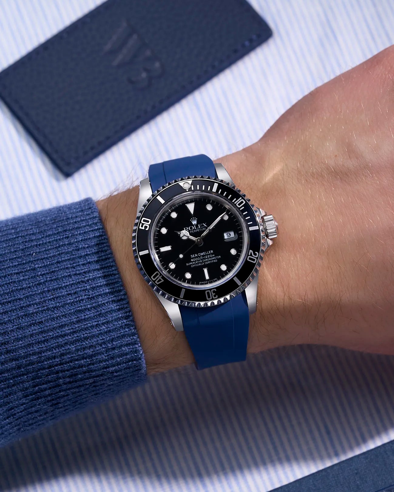 Rolex Sea-Dweller 16600 fitted with integrated blue FKM rubber strap and original clasp, worn on wrist