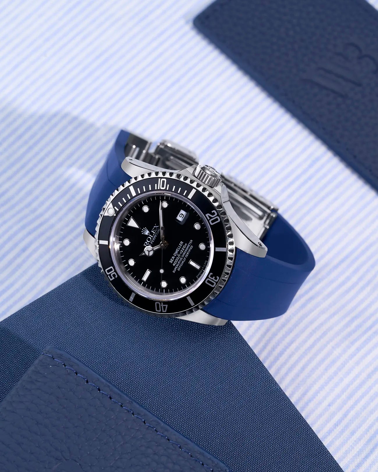 Rolex Sea-Dweller 16600 with integrated blue rubber strap and original clasp shown on fabric background