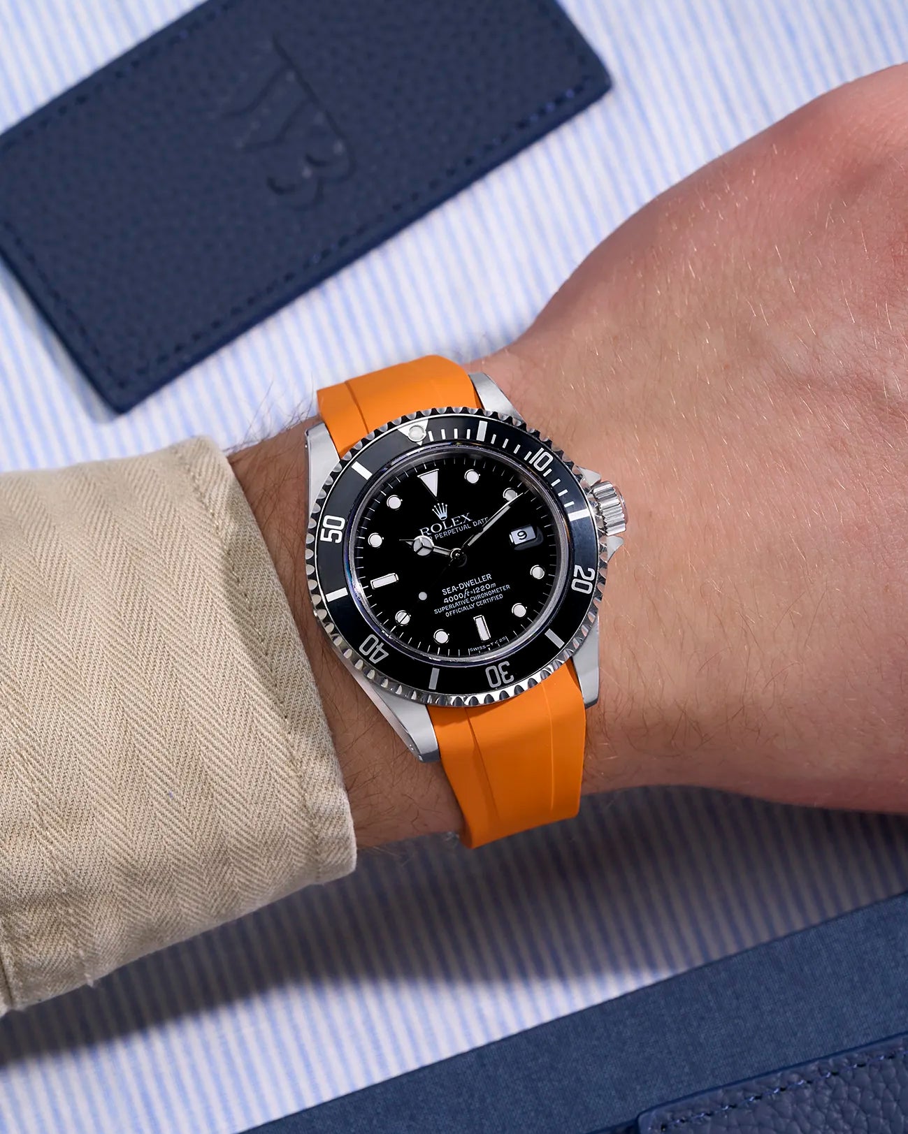 Rolex Sea-Dweller 16600 on wrist with orange FKM rubber strap and integrated original clasp