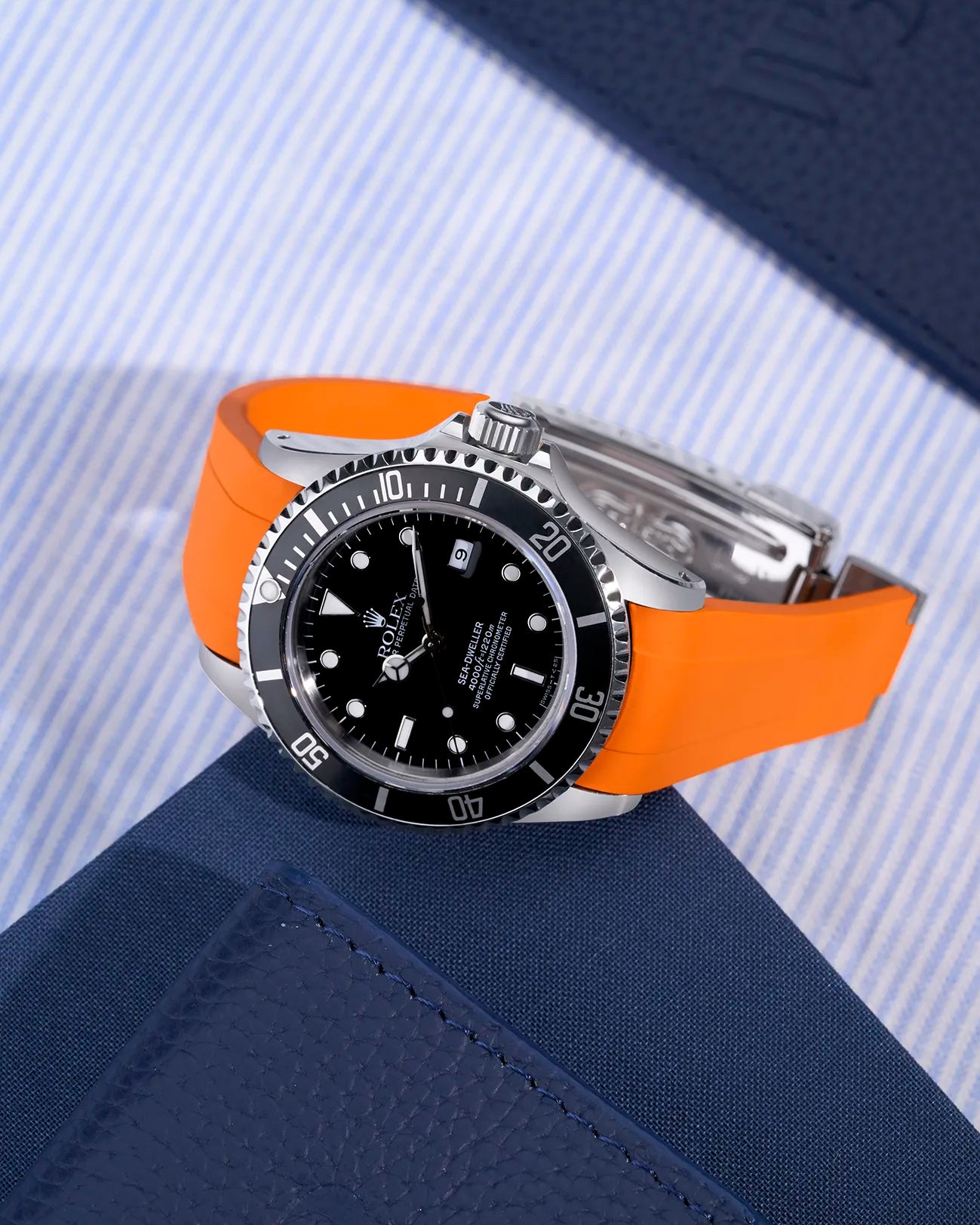 Rolex Sea-Dweller 16600 with orange integrated rubber strap and original clasp on display