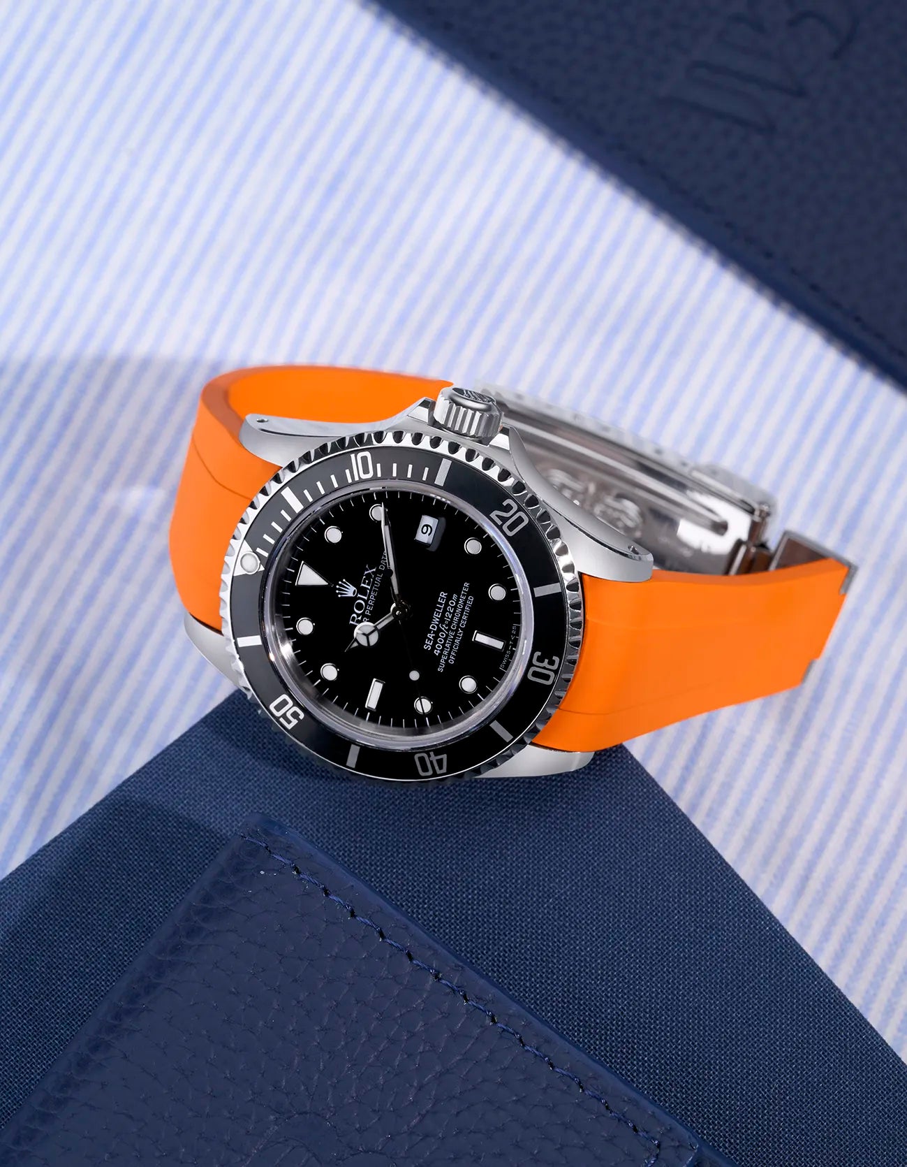 Rolex Sea-Dweller 16600 with orange integrated rubber strap and original clasp on display