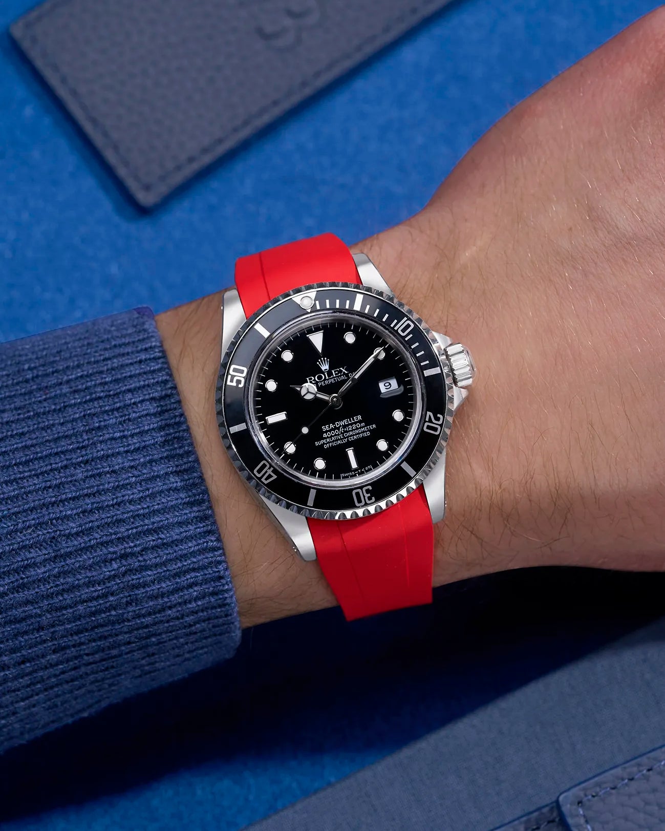 Wrist shot of Rolex Sea-Dweller 16600 on red FKM rubber strap with original clasp integration