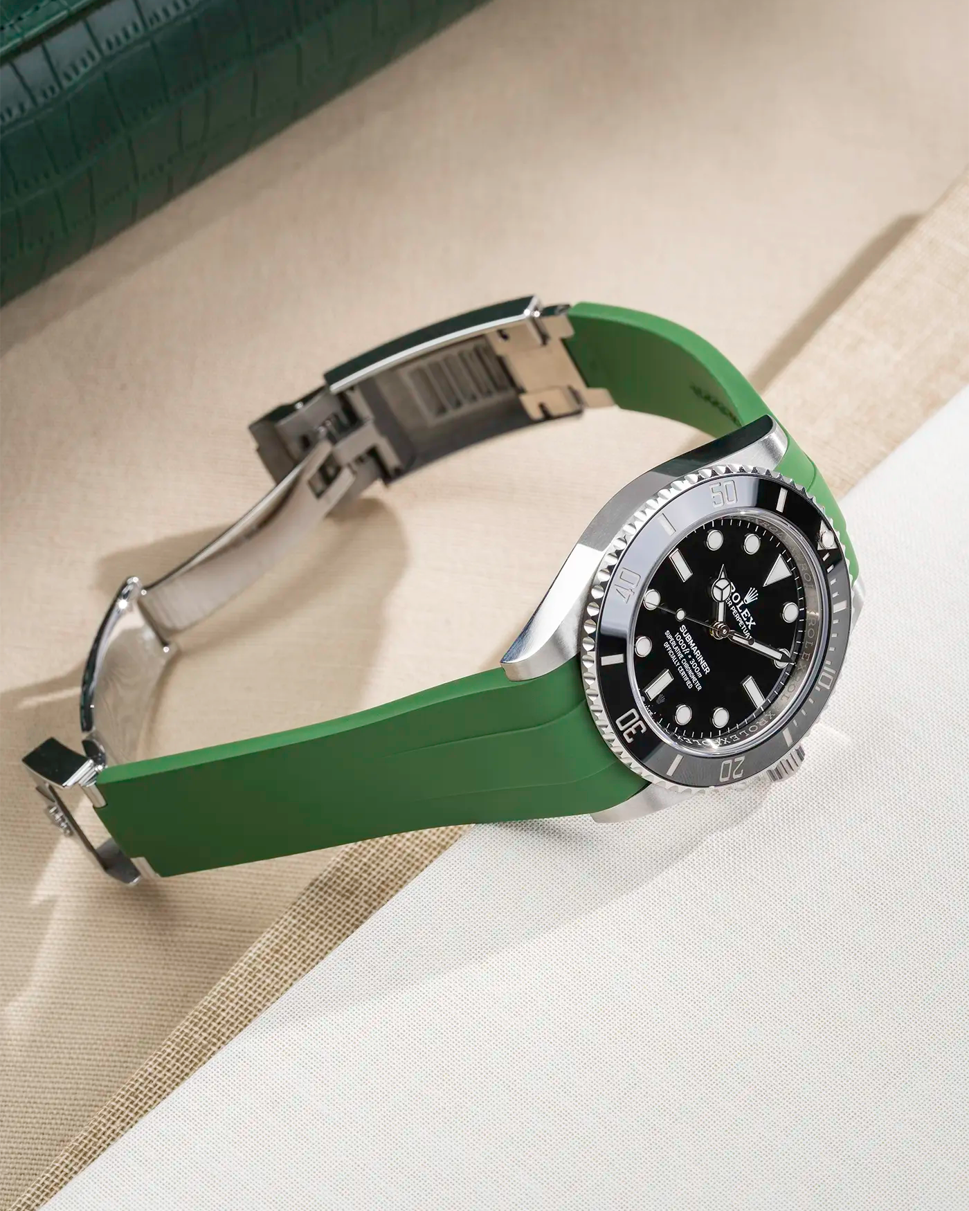 Rolex Submariner 41 with green Classic Smooth FKM Rubber Strap sitting on the watch, integrated with original clasp – lifestyle product photo side angle with clasp open
