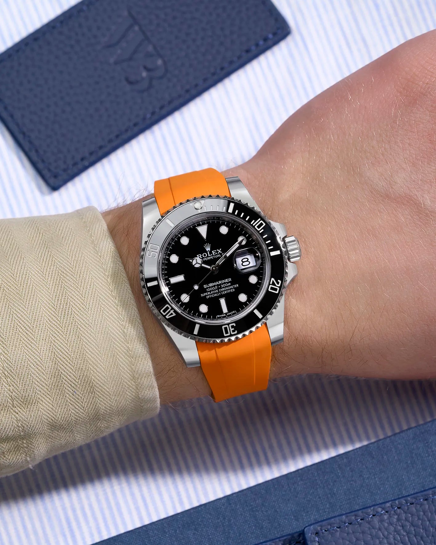 Rolex Submariner 116610LN on wrist with vibrant orange rubber strap and original clasp integration