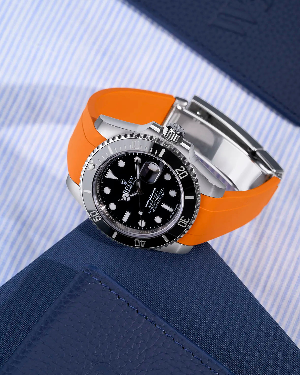 Rolex Submariner 116610LN with orange rubber strap integrated with original Rolex clasp – flat lay