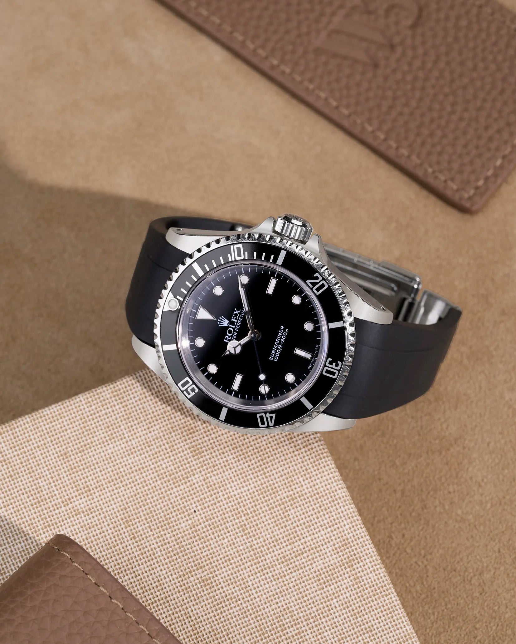 Rolex Submariner 16610/14060 with black FKM strap – flat lay showcasing original clasp integration and sporty luxury look