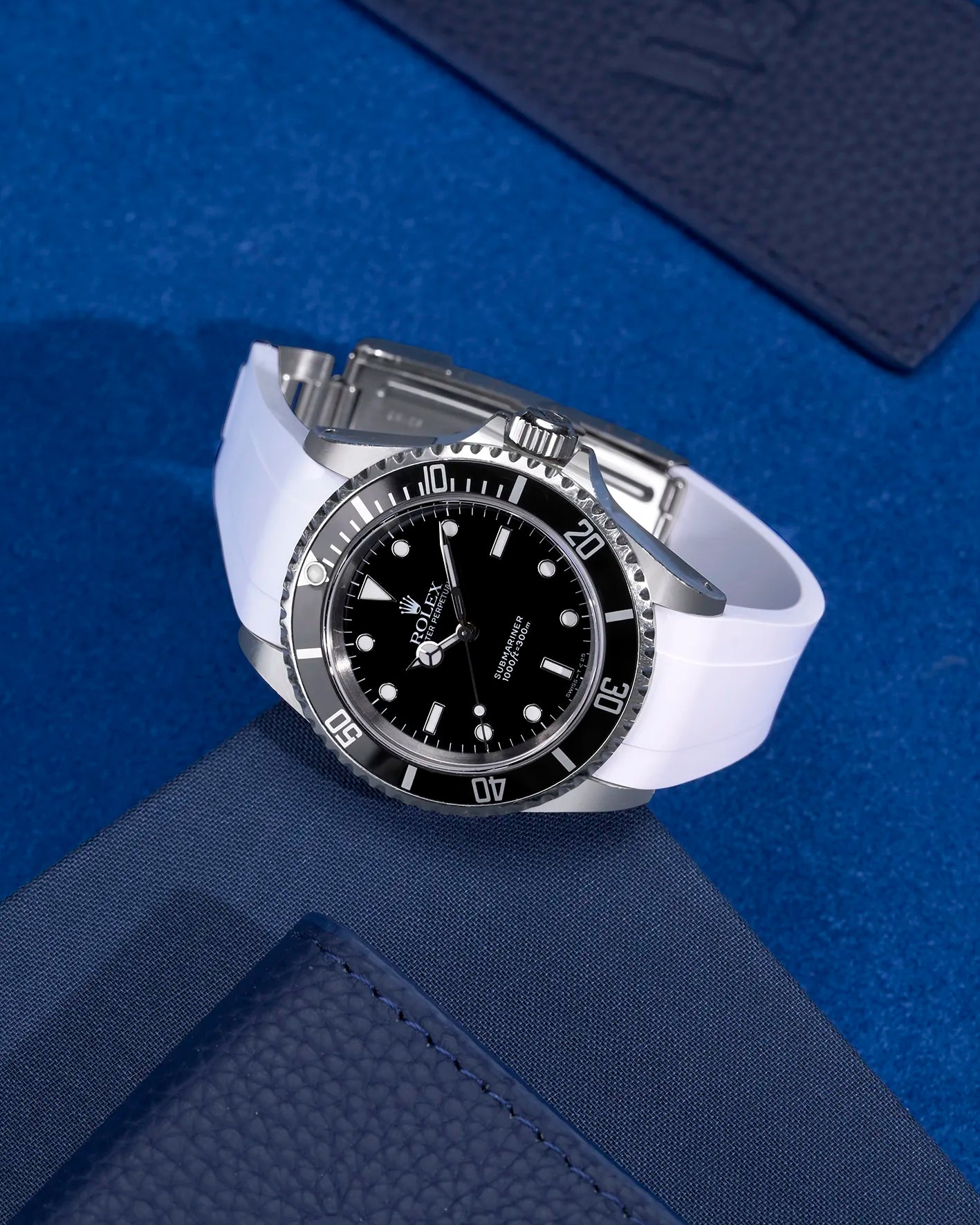 Rolex Submariner 16610 and 14060 on white FKM rubber strap integrated with original clasp – display on blue fabric