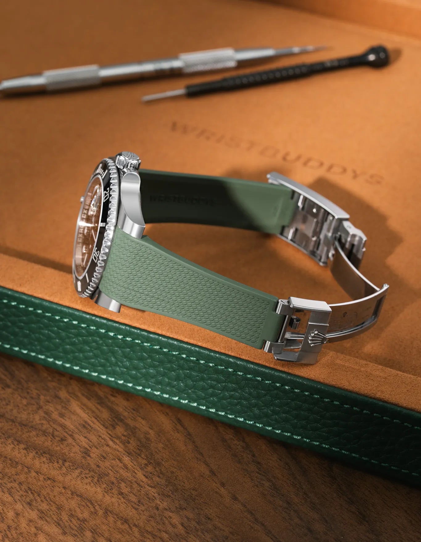 Green Vertech FKM rubber strap for Rolex Submariner (116610/126610), integrated case fit for original clasp, resting on a leather watch tray.