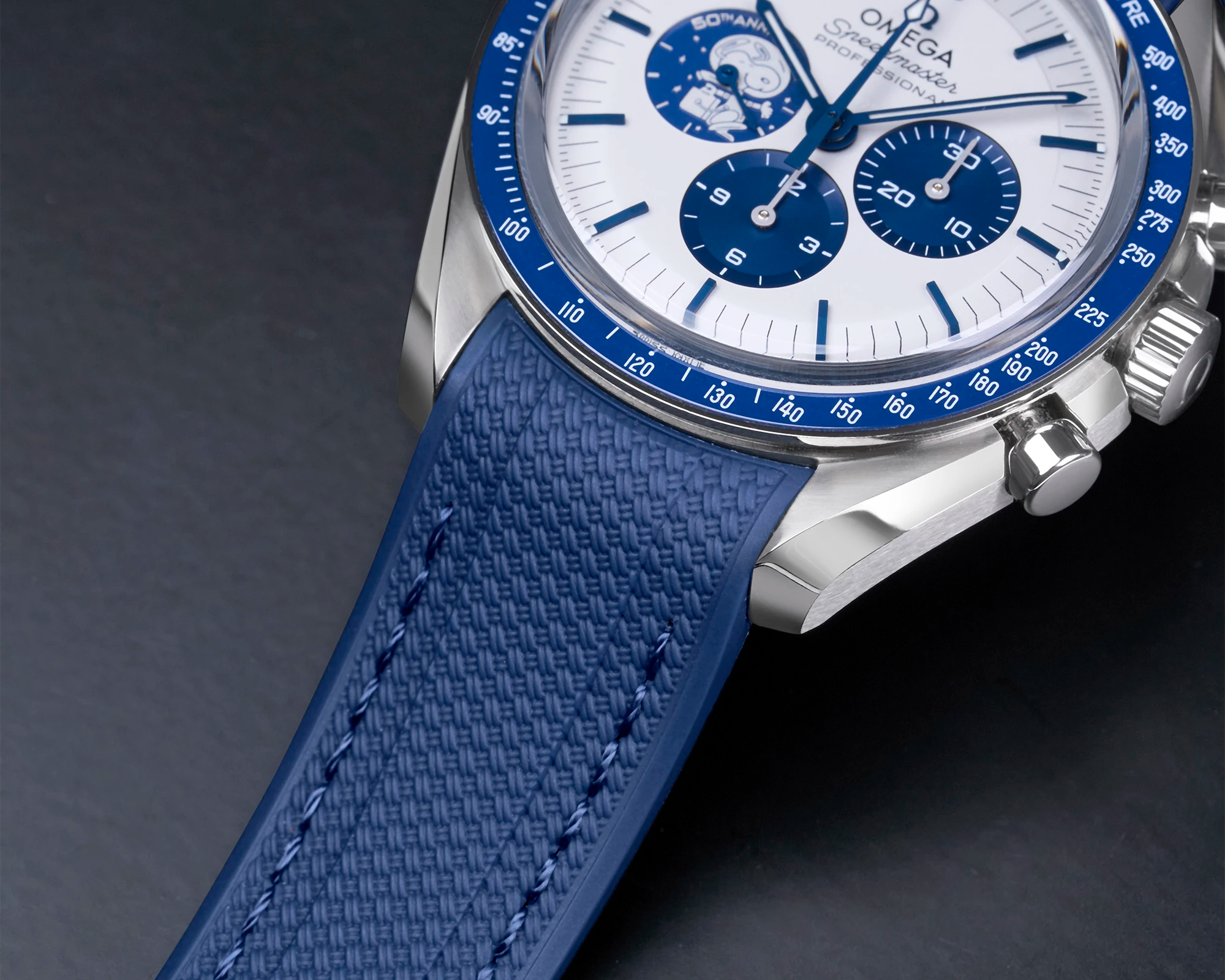 Close-up of blue rubber watch strap on Omega Speedmaster, engineered for a perfect fit using 3D scanning technology