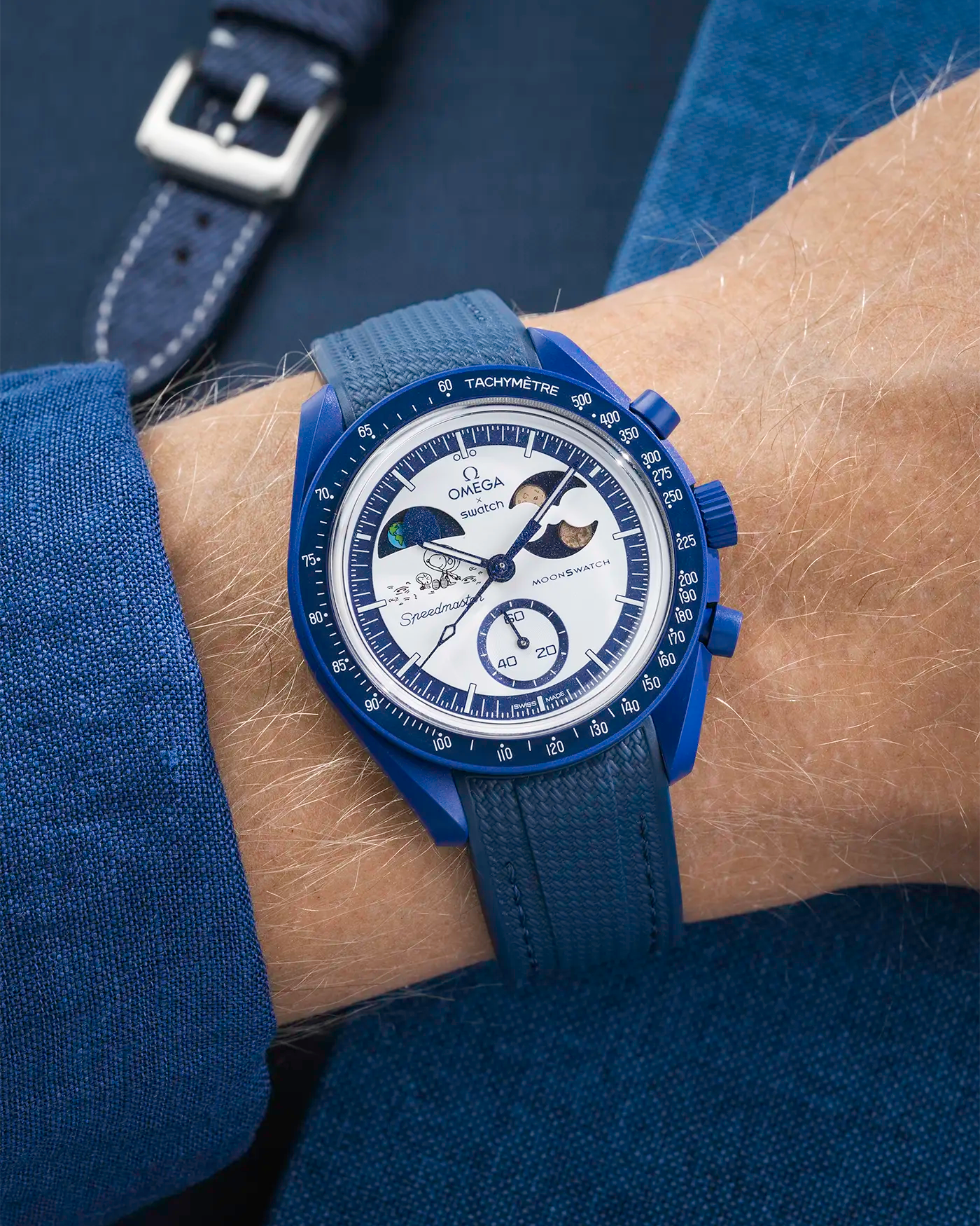 Wrist shot on blue Rubber Strap For Omega x Swatch MoonSwatch Mission To Earthphase - Moonshine Gold with blue background