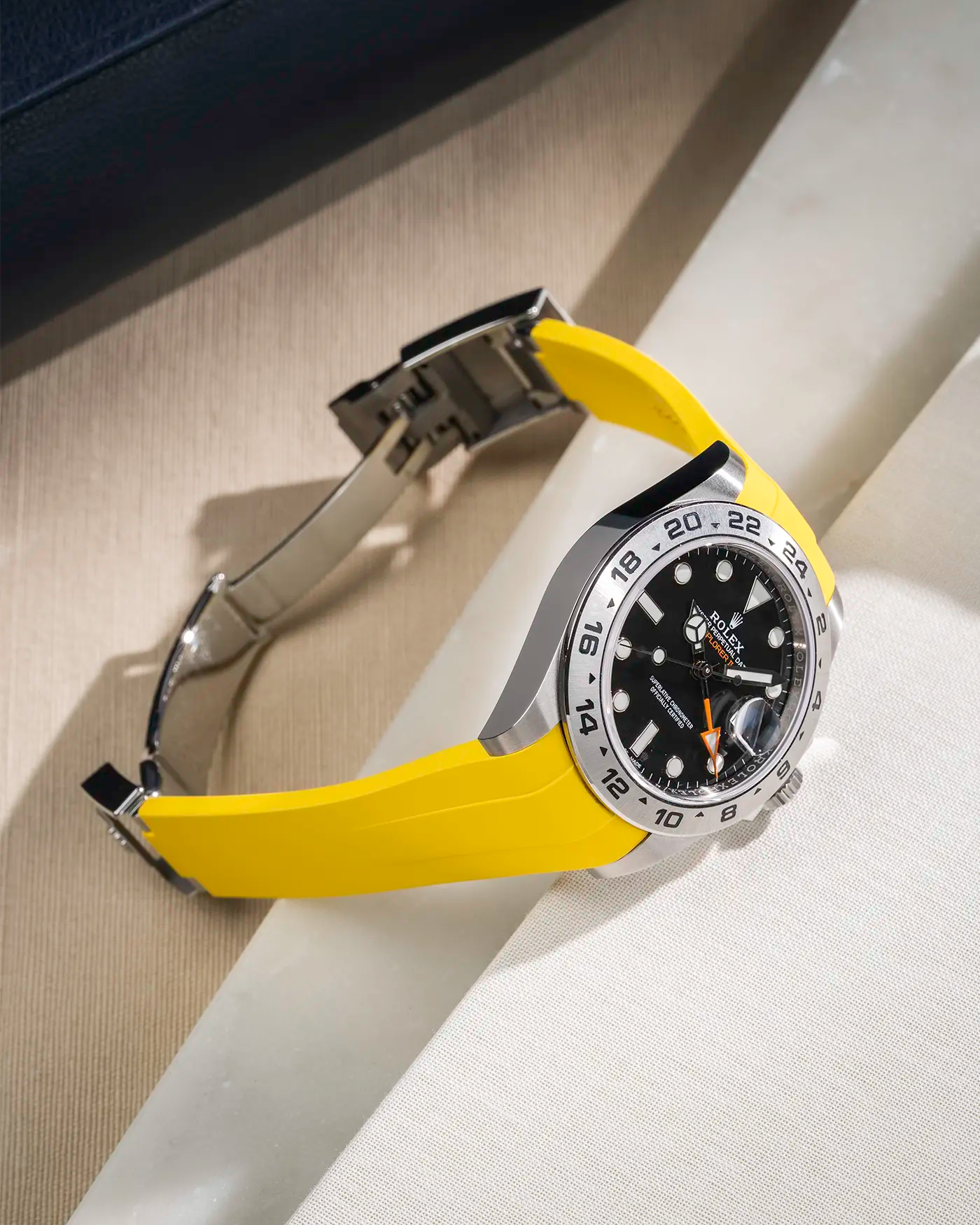 Yellow FKM rubber strap integrated with original clasp for Rolex Explorer 216570, displayed on table with open clasp