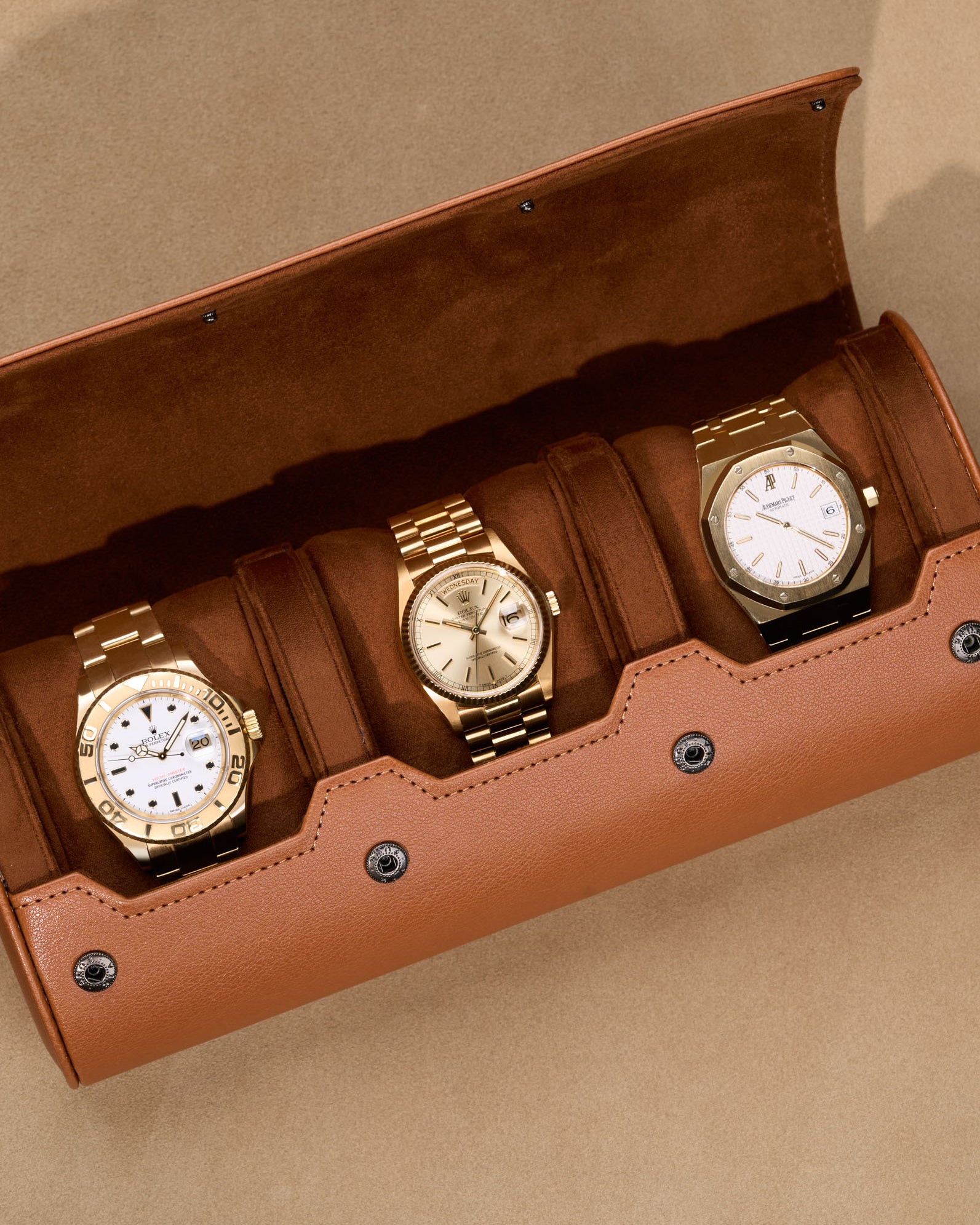 Opened 3 Slot Watch Roll in brown with three luxury gold watches inside
