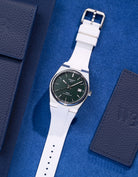 Tissot PRX Powermatic 80 with white FKM rubber strap on blue textured background