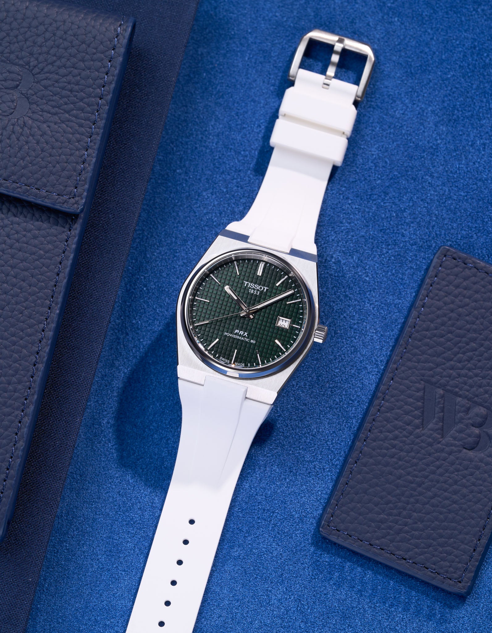 Tissot PRX Powermatic 80 with white FKM rubber strap on blue textured background