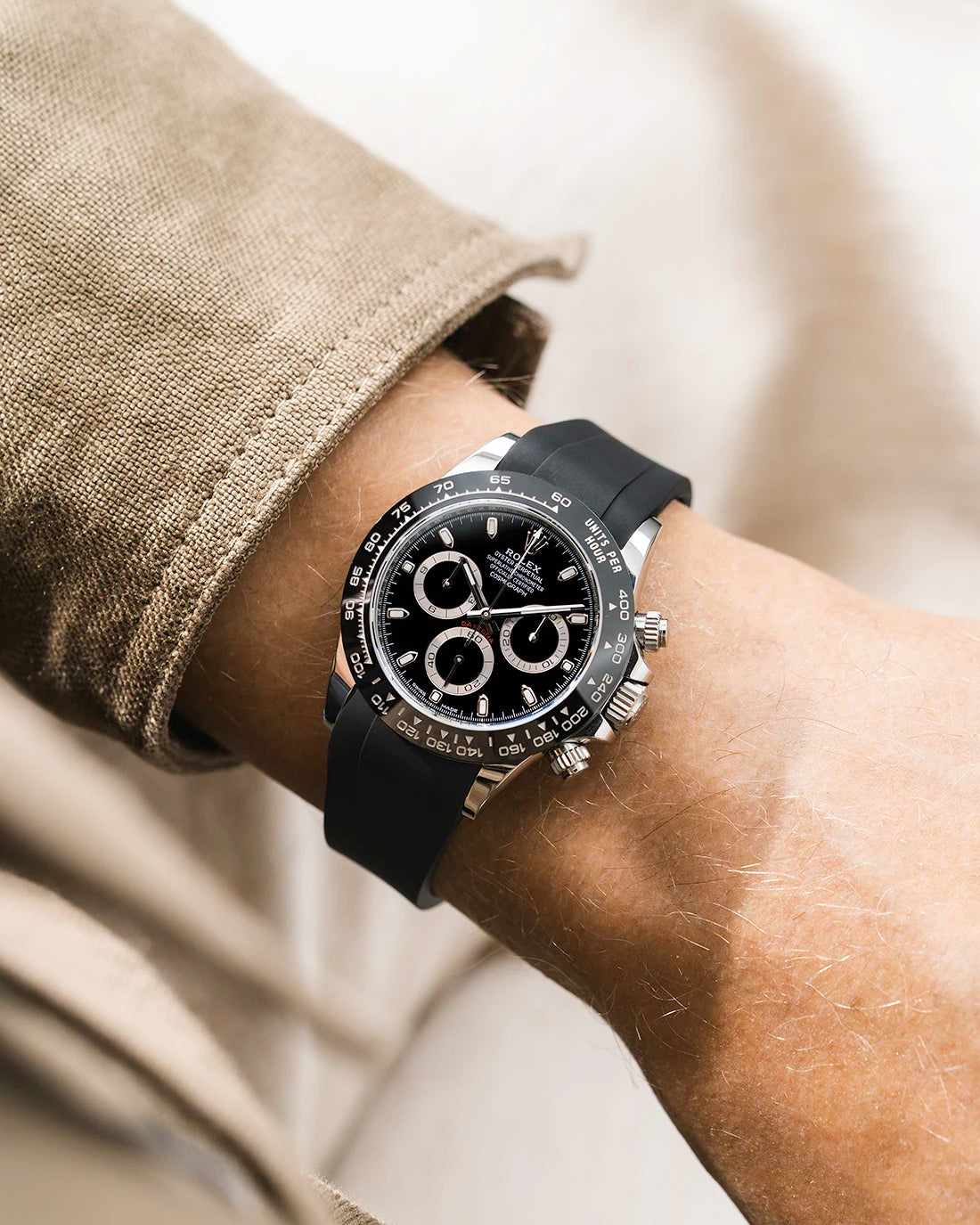 Black integrated FKM rubber strap with original clasp on Rolex Daytona 116500 black dial ceramic bezel wrist shot classic smooth surface