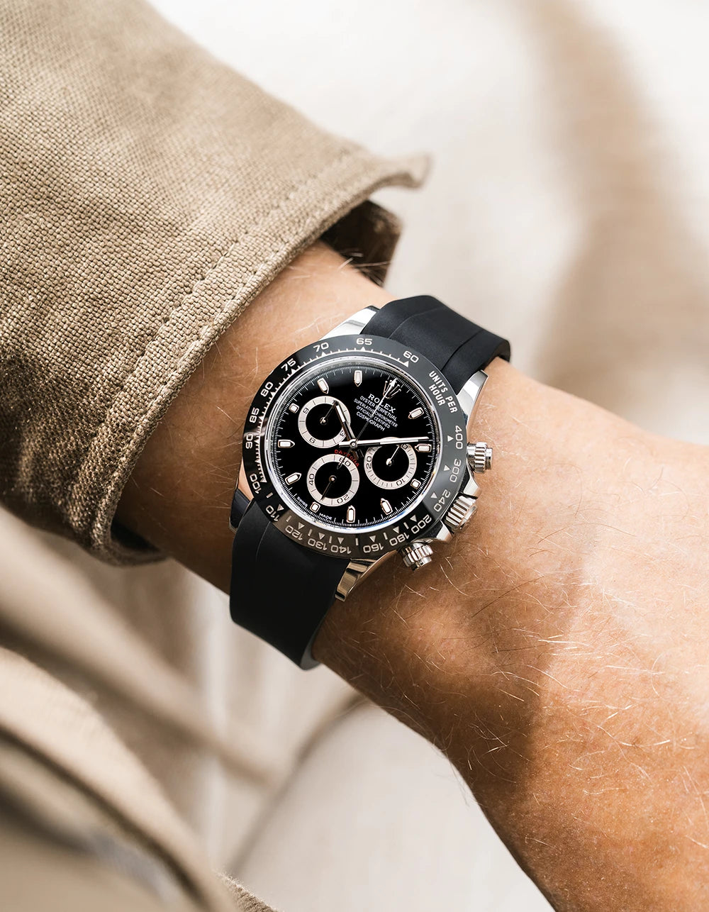 Black integrated FKM rubber strap with original clasp on Rolex Daytona 116500 black dial ceramic bezel wrist shot classic smooth surface