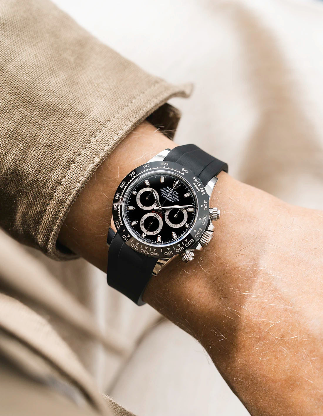 Black integrated FKM rubber strap with original clasp on Rolex Daytona 116500 black dial ceramic bezel wrist shot classic smooth surface