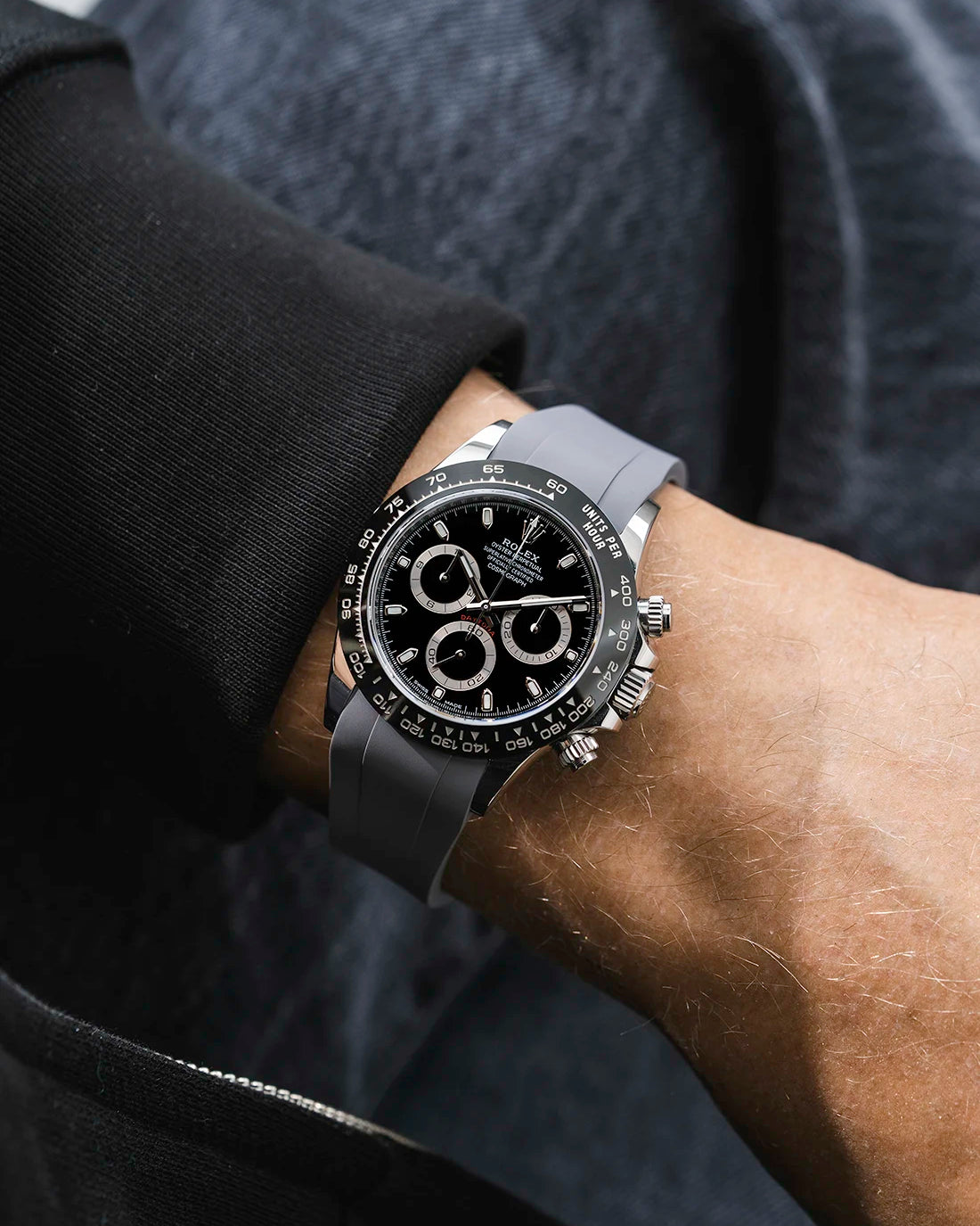 Grey integrated FKM rubber strap with original clasp on Rolex Daytona 116500 black dial ceramic bezel wrist shot classic smooth surface